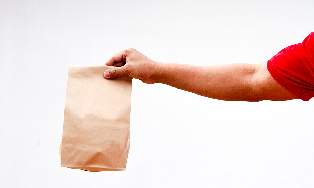 Man holding a paper bag with food