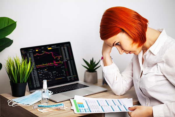 Sad woman looking at falling stock charts